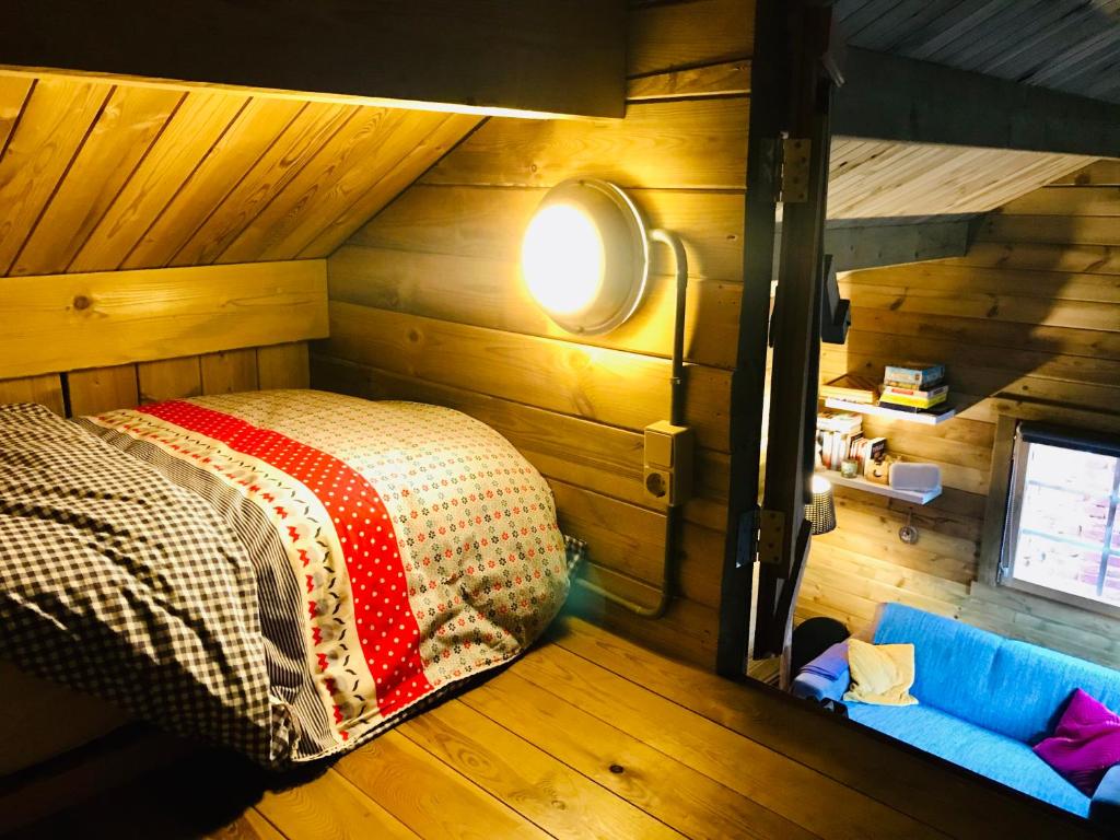 een slaapkamer met een bed in een kamer met houten wanden bij Tiny House Andersom Anders in Bad-Nieuweschans