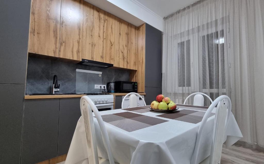 uma cozinha com uma mesa com uma taça de fruta em Mega Apart in Almaty em Almaty