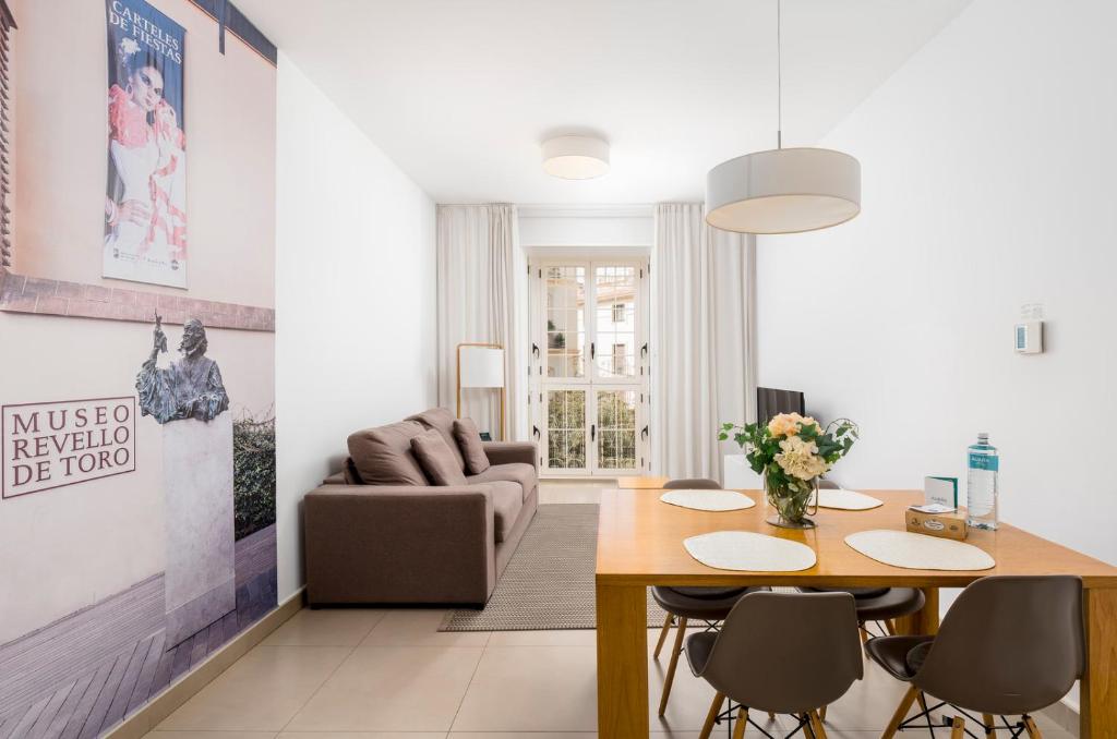 ein Wohnzimmer mit einem Tisch und einem Sofa in der Unterkunft Suites Del Pintor in Málaga