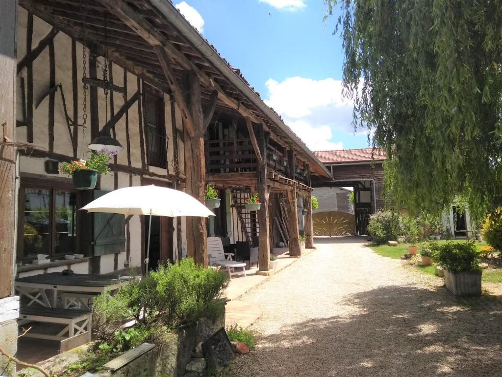 an outside view of a building with an umbrella at La Varnière in Montier-en-Der