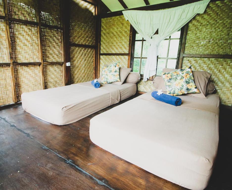 a living room with two beds and a couch at Bale Jukung in Tanjung