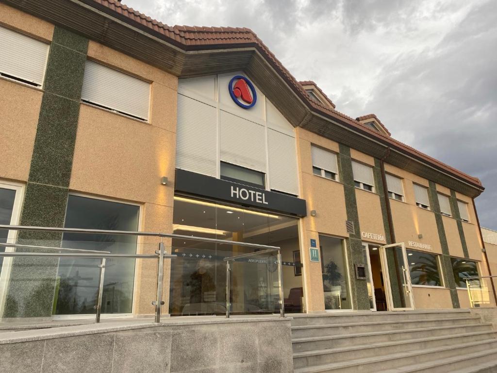 een hotelgebouw met een klok aan de voorkant bij Hotel Arias Aeropuerto in Monte