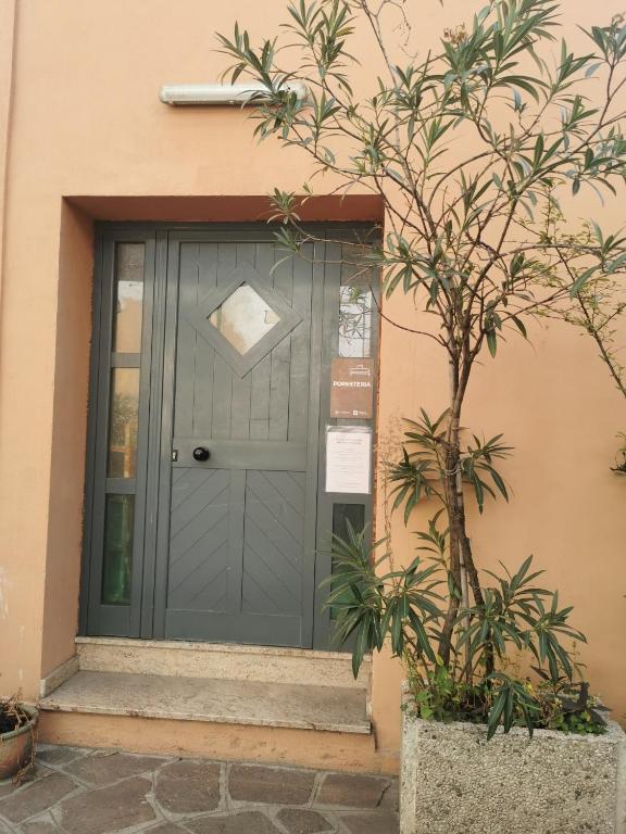 a blue door on a house with a plant at locanda foresteria in Milan