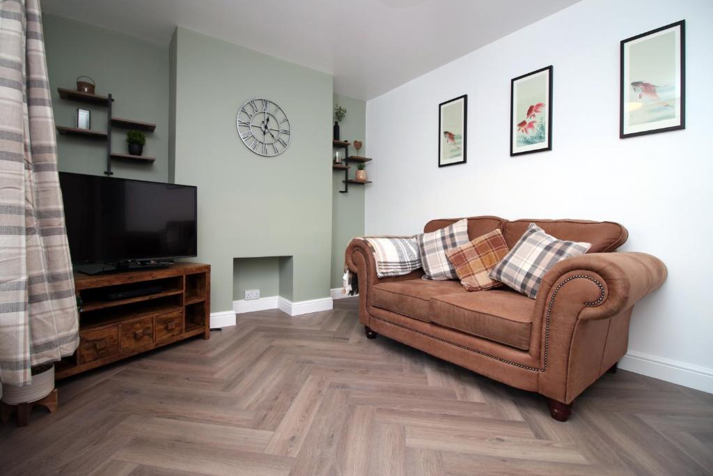 a living room with a couch and a flat screen tv at Wern farm cottage in Pontypool