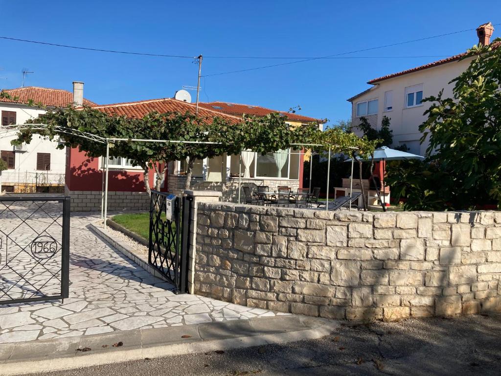 eine Steinmauer mit einem Tor vor einem Haus in der Unterkunft Casa Letizia in Umag