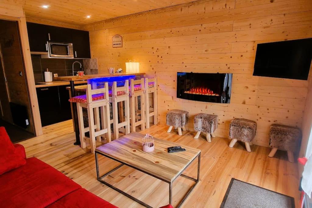 - un salon avec une cheminée dans une cabane en rondins dans l'établissement Charmant T2 rénové- Praloup 1600-parking privé, proche station, à Uvernet