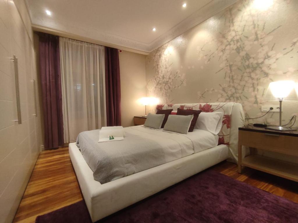 ein Schlafzimmer mit einem großen weißen Bett mit zwei Kissen in der Unterkunft HABITACION EN VIVIENDA GRAN VIA BILBAo in Bilbao