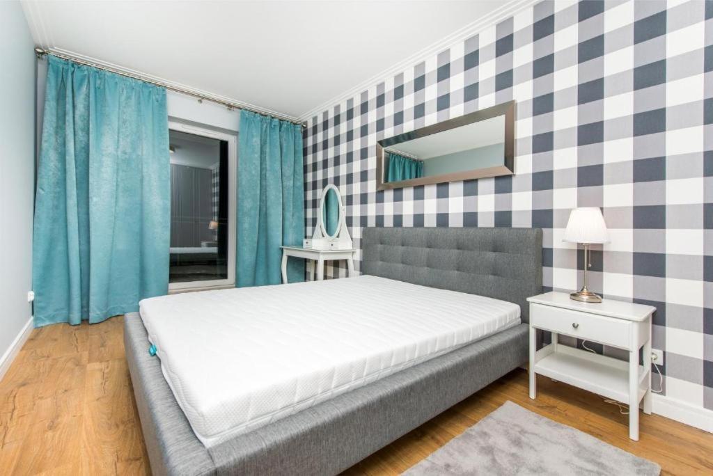 a bedroom with a bed and a checkered wall at Cztery Oceany 209 in Gdańsk