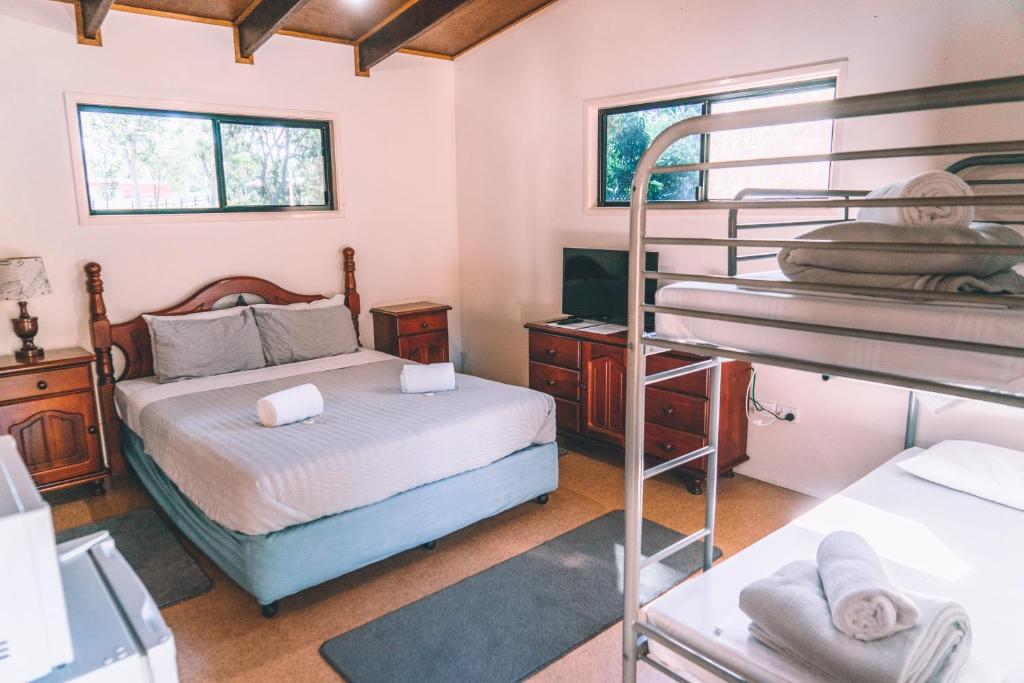 a bedroom with two bunk beds and a desk at 1770 Southern Cross Travellers Retreat in Agnes Water