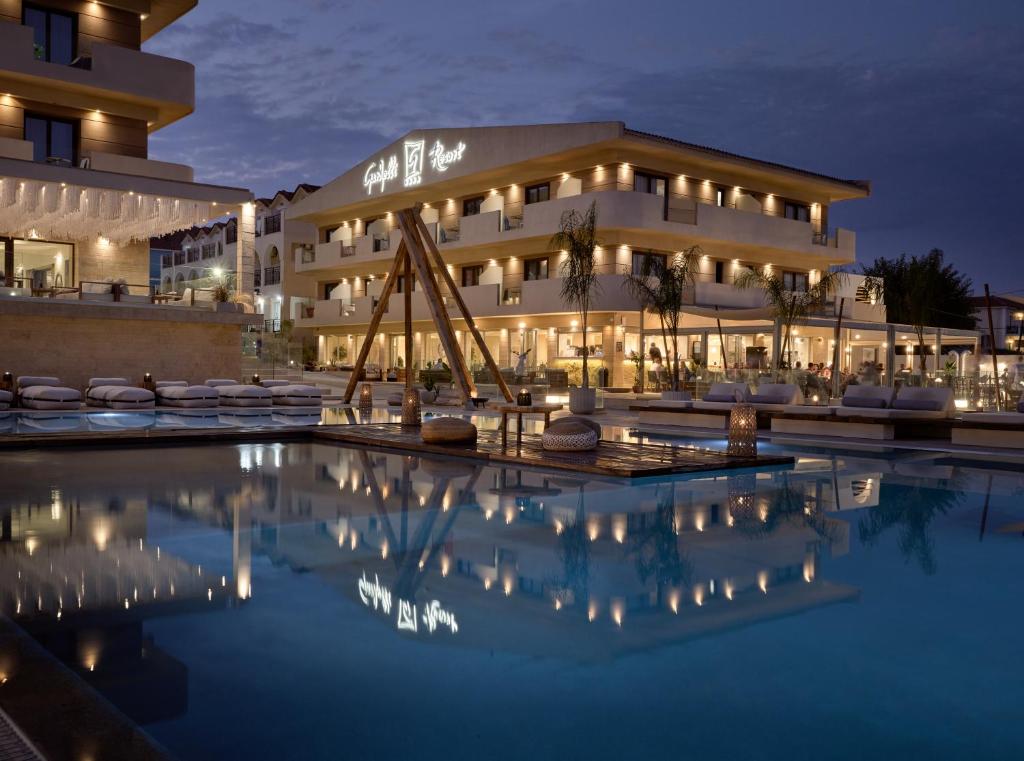 a hotel with a swimming pool at night at GARDELLI RESORT in Laganas