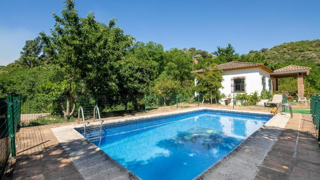 una piscina di fronte a una casa di Casa Puente Palo Igualeja by Ruralidays a Igualeja