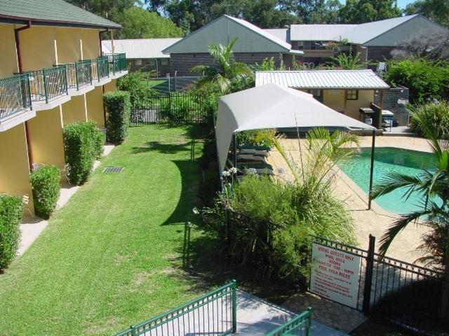 a yard with an umbrella and a swimming pool at St Marys Park View Motel in St Marys