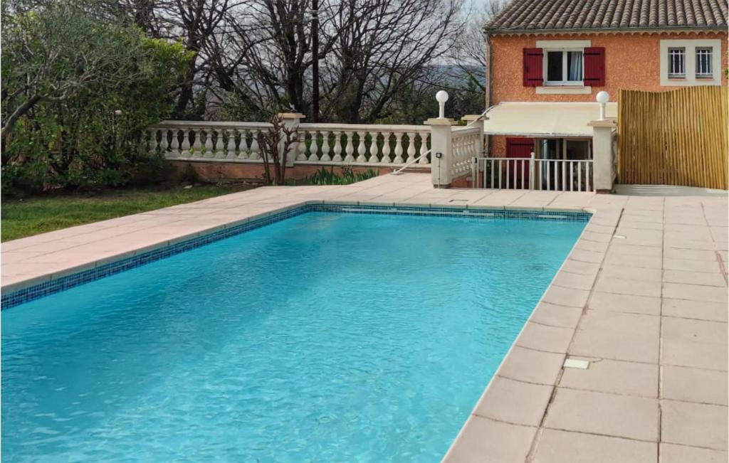 a swimming pool in front of a house at Cozy Home In St-Quentin-La-Poterie in Saint-Quentin-la-Poterie