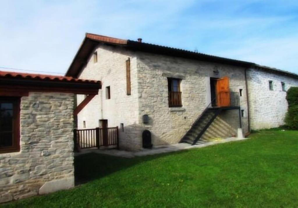 una casa de piedra con una escalera que conduce a una puerta en Casa Rural Arteondo en Orduña