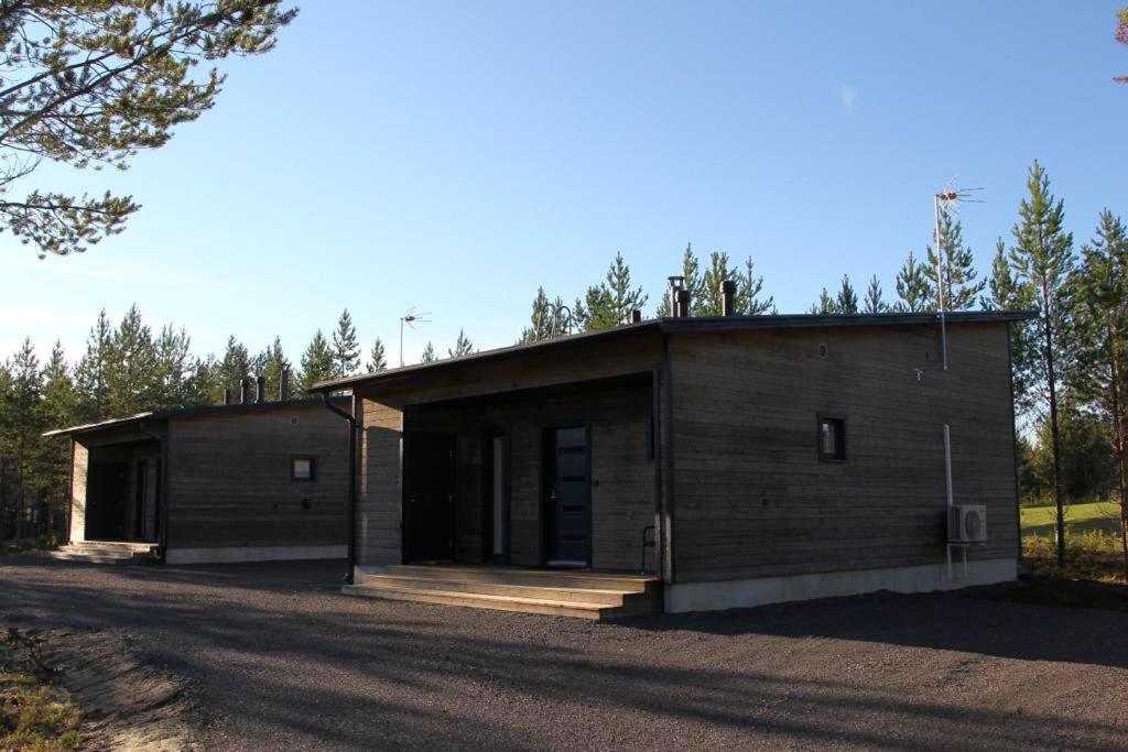 um pequeno edifício de madeira numa estrada de terra em Sankivillat em Oulu