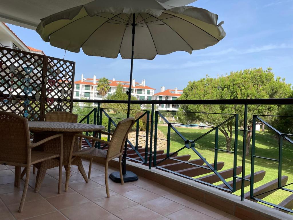 a balcony with a table and an umbrella at House of Rising Sun in Quarteira