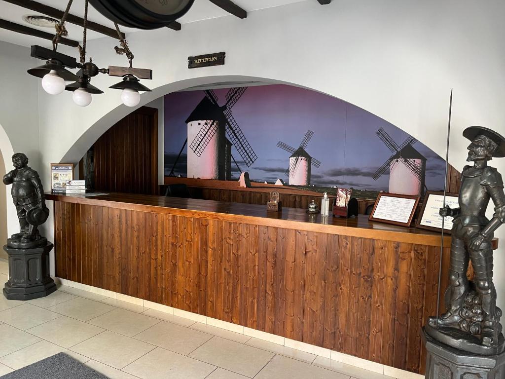 a lobby with a bar with a statue of a man at Hotel Cervantes in Zafra