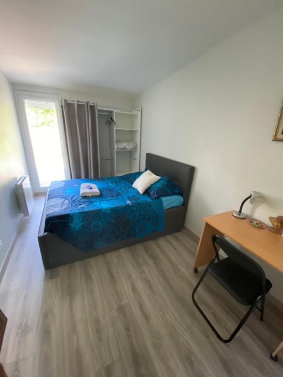 a bedroom with a bed and a desk and a desk at Agréable chambre in Menucourt