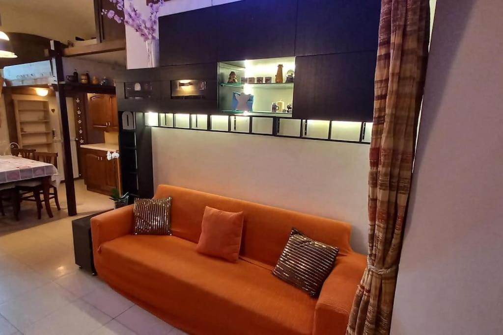 un divano arancione in soggiorno di Residenza nel borgo romano a Mentana