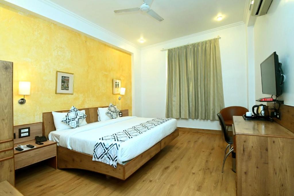 Habitación de hotel con cama y TV en Hotel Yulia- Le Amour Inn, en Jaipur