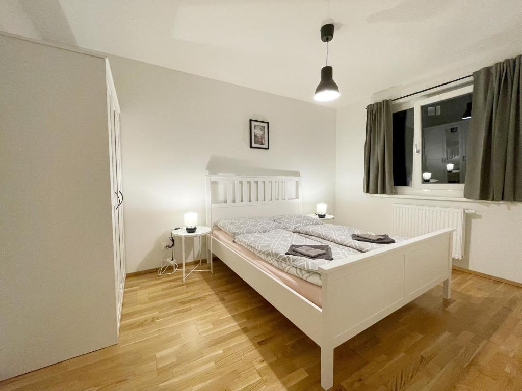 - une chambre avec un lit blanc et une fenêtre dans l'établissement MUZETA11 - Modern Town Apartment with Balcony, à Vienne