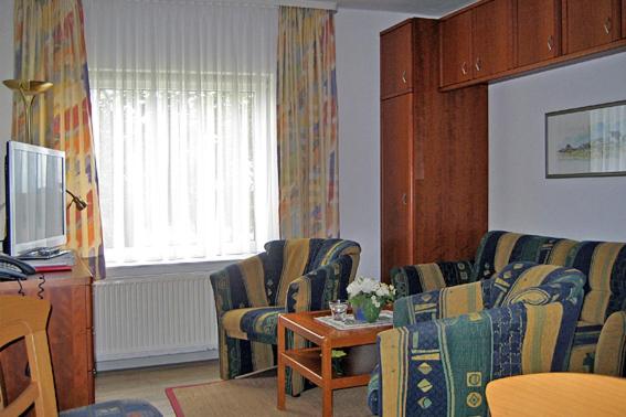ein Wohnzimmer mit 2 Stühlen und einem Tisch in der Unterkunft Dünenwind Dünenwind 02 in Norderney
