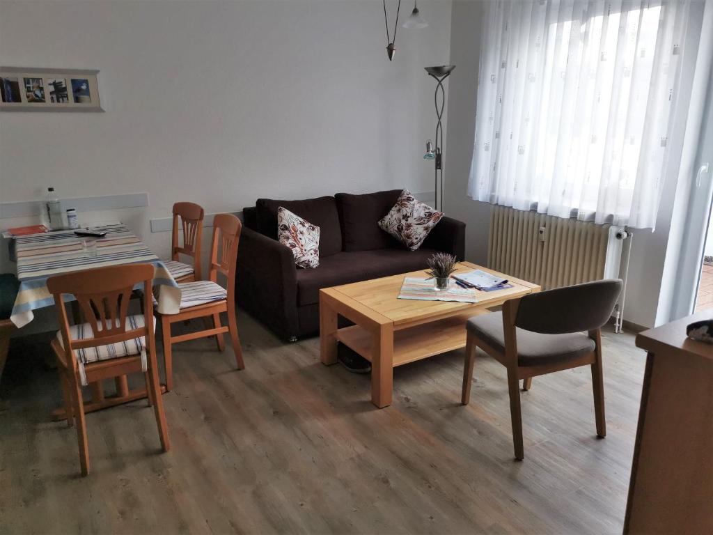 ein Wohnzimmer mit Sofa, Tisch und Stühlen in der Unterkunft Haus Sieben Wohnung 1 Roonstraße 3 in Norderney