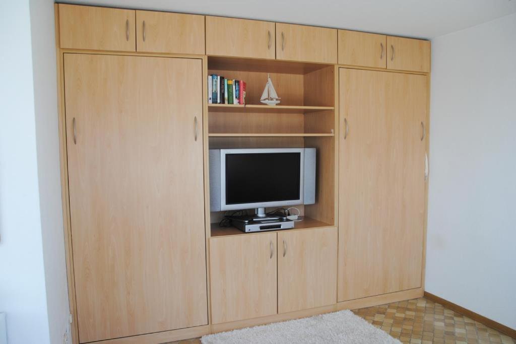 a wooden entertainment center with a television in it at Alte Teestube Alte Teestube 14 in Norderney