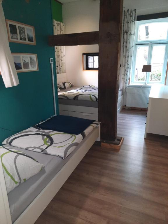 Duas camas num quarto com paredes verdes e pisos em madeira em Ferienwohnung Noltenius em Bülstedt