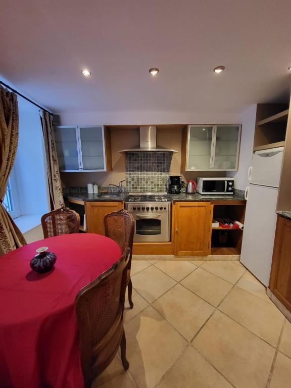 a kitchen with a table with a red table cloth on it at La chapellerie in Caunes-Minervois