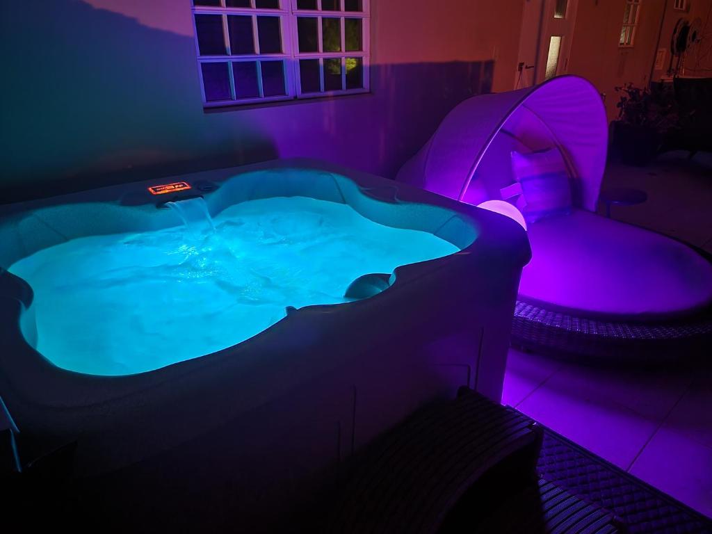 a hot tub in a room with purple lights at Luxury Retreat with Private Jacuzzi and Mountain Views FREE Parking in Ponce