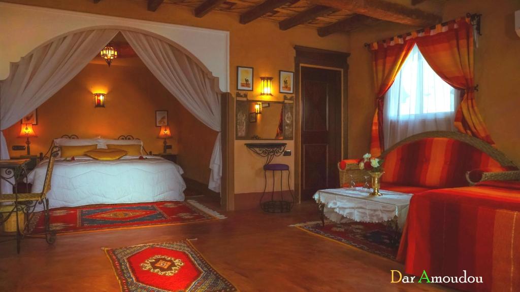 a bedroom with a bed and a table and a window at Dar Amoudou in Ouarzazate