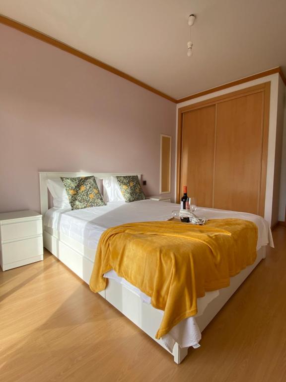 - une chambre avec un grand lit et une couverture jaune dans l'établissement Apartamento Rua do Sol by Localhosting, à Albufeira