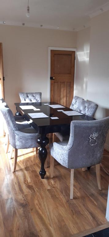 jadalnia z czarnym stołem i krzesłami w obiekcie Our Guests Are Royal (EL) Wellingborough w mieście Wellingborough