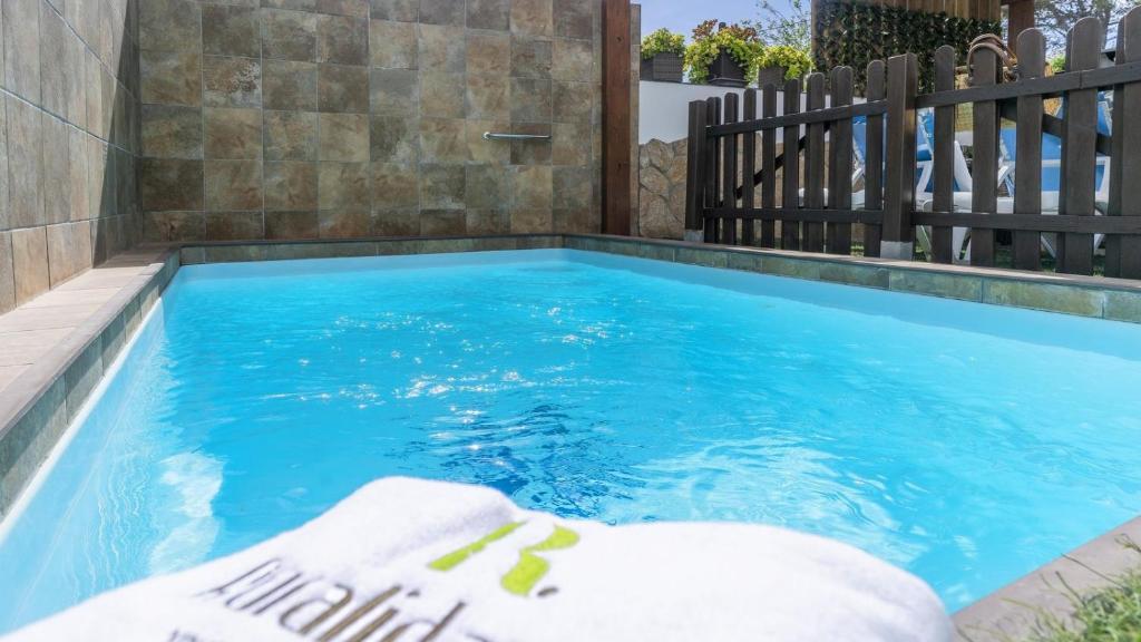 a swimming pool with a fence and blue water at Casa El Duque Zaira Vejer de la Frontera by Ruralidays in Vejer de la Frontera