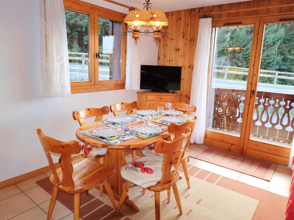 ein Esszimmer mit einem Tisch, Stühlen und einem TV in der Unterkunft Appartement Morillon Village, 2 pièces, 5 personnes - FR-1-624-99 in Morillon