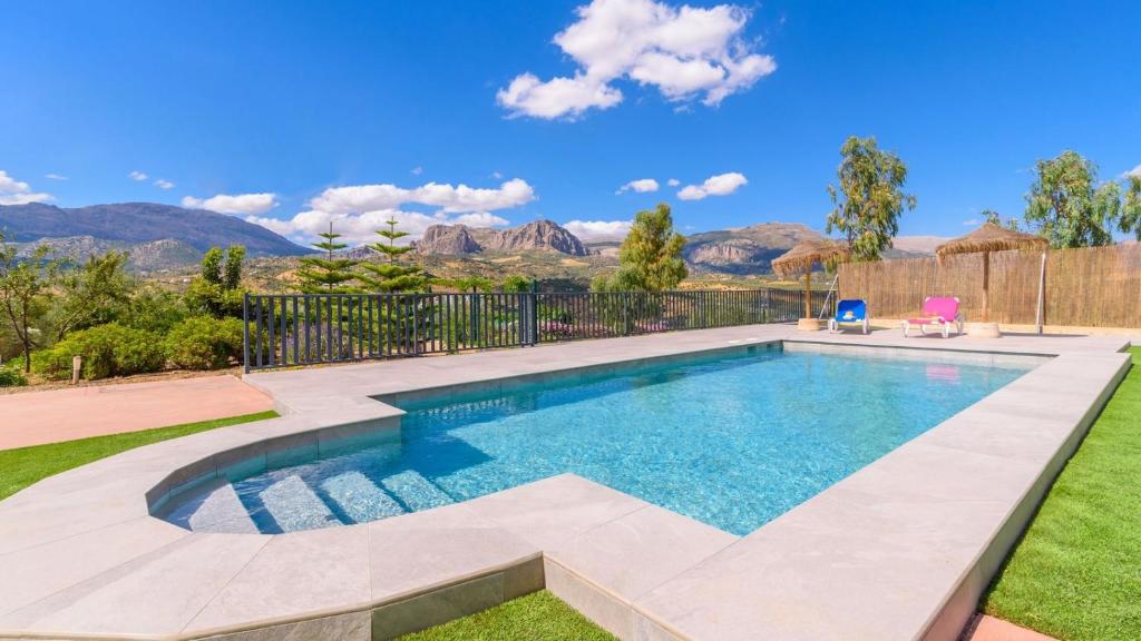 una piscina en un patio con montañas al fondo en Casa Rural Tajo de Gómer Riogordo by Ruralidays, en Ríogordo