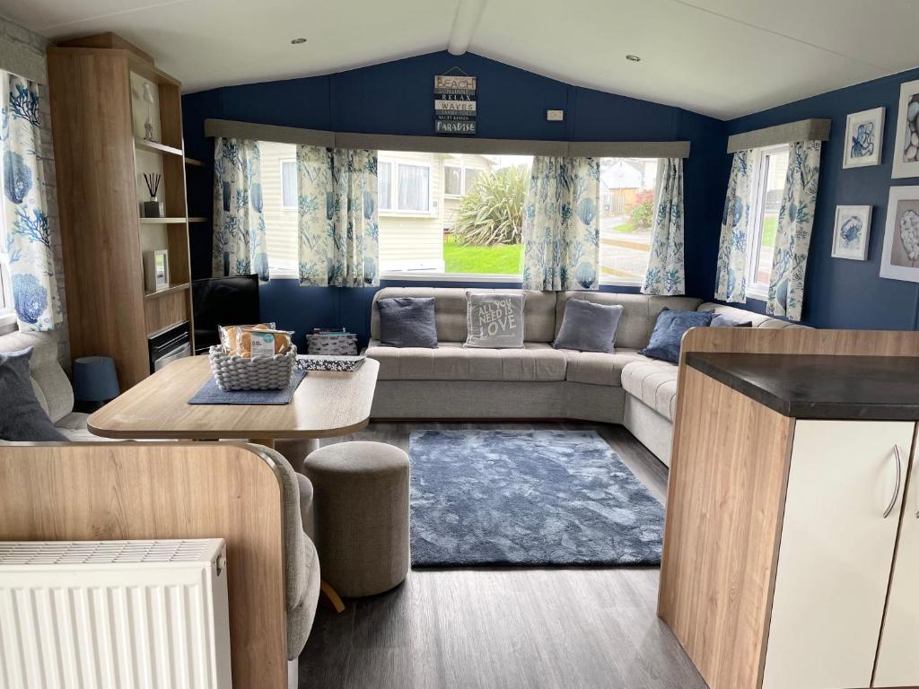 a living room with a couch and a table at Newquay Bay Resort - Sea Breeze 61 in Newquay
