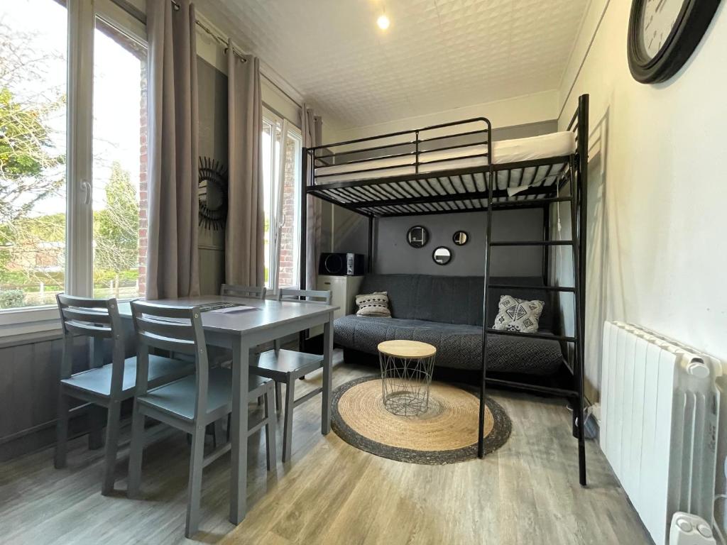a bedroom with a loft bed and a table and chairs at Les bords du lac in Cany-Barville