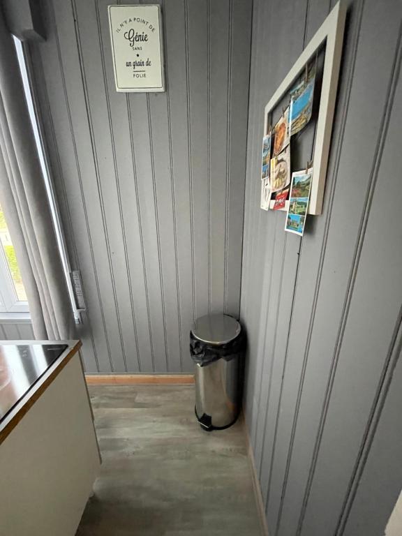 a hallway with a trash can next to a wall at Les bords du lac in Cany-Barville