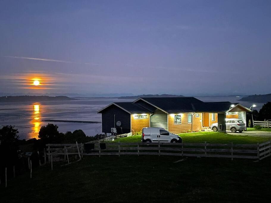 uma casa com um carro estacionado em frente em Bella casa de campo con panorámica vista al mar em Dalcahue