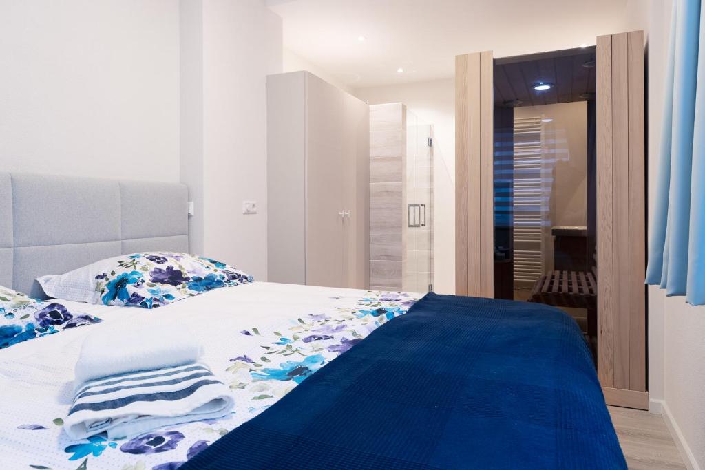 a bed with blue and white sheets and pillows at Kustappartementenkatwijk 2F in Katwijk aan Zee