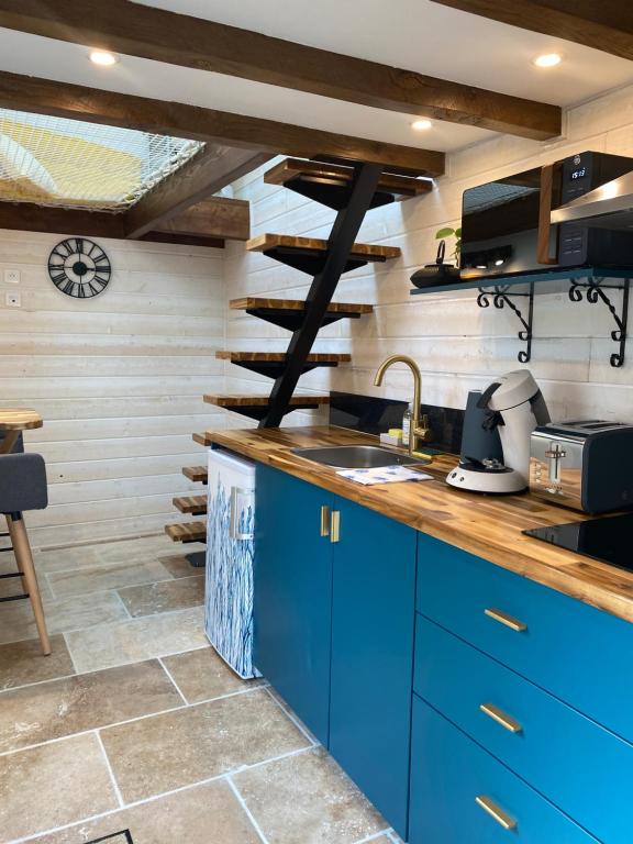 - une cuisine avec des placards bleus et un évier dans l'établissement La Tiny Blue - maison insolite pour 2 - sans Tv, à Saint-Aignan