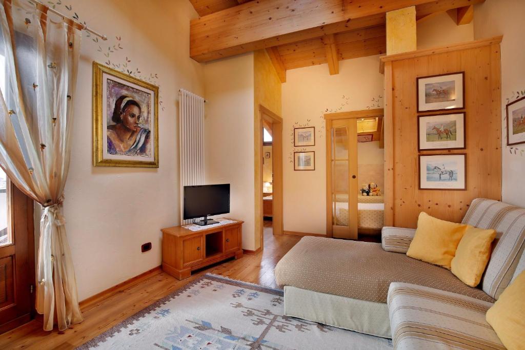 salon z kanapą i telewizorem w obiekcie Park Hotel Leonardo w mieście Moena