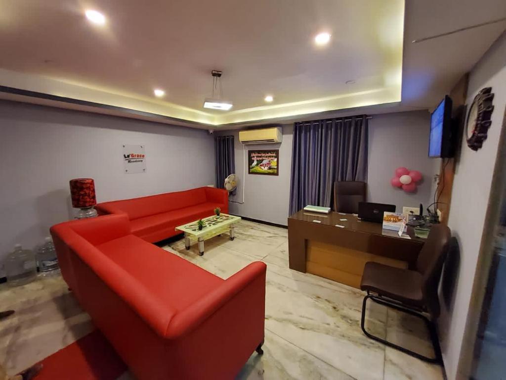 sala de estar con sofá rojo y escritorio en Le Grace Annasalai, en Chennai