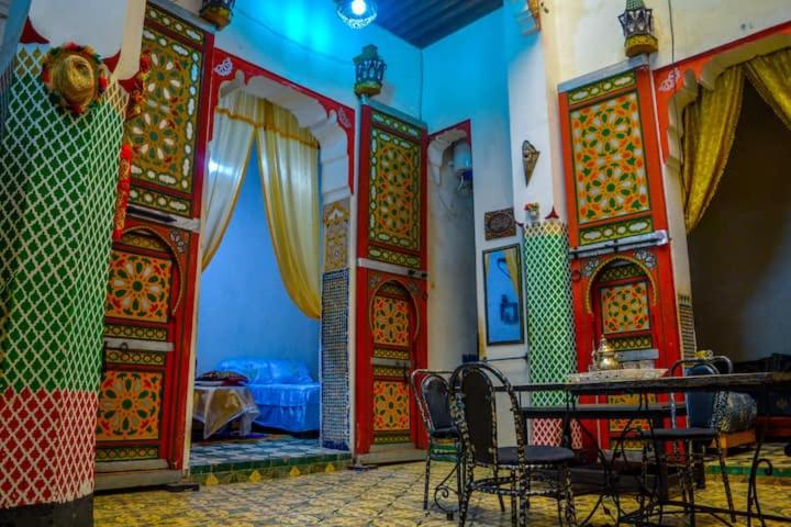 a room with a table and chairs and a bed at Riad Rajy in Fez