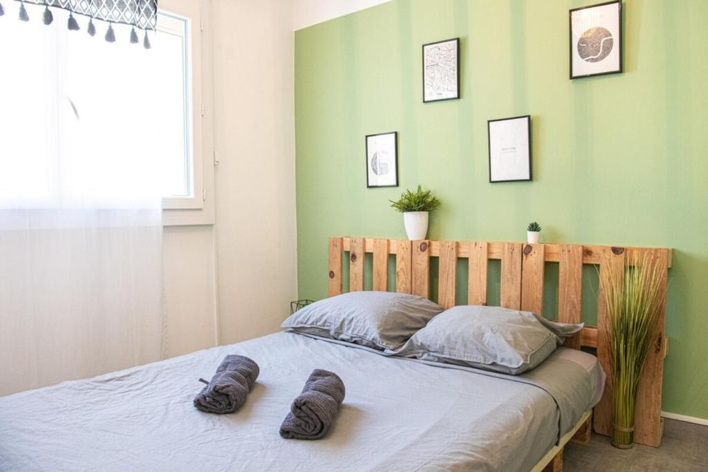 a bedroom with a bed with two pairs of socks on it at L&#39;Escale - 2 Chambres balcon à 5 min des plages in Marseille