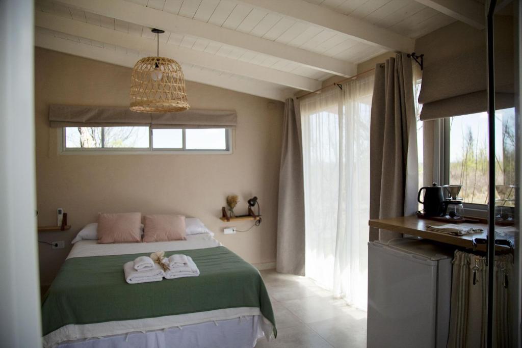 een slaapkamer met een bed met handdoeken erop bij Las Quimeras in Nono