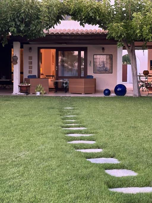 a stepping stone path in the grass in front of a house at Villa Maria-Stunning Villa in Porto Hydra in Thermisía