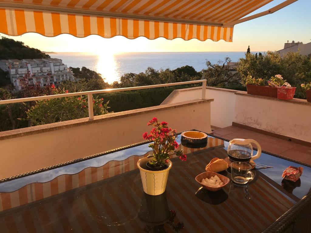 una mesa en un balcón con vistas al océano en Apartamento con piscina - Tossa - Magníficas vistas al mar, en Girona